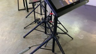 Профессиональная стойка с аппаратурой и дисплеями для управления фотозоной Bullet Time, видна фотовидеотехника и кабели на полу.