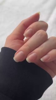 Рука крупным планом с квадратной натуральной формой ногтей, холодный серо‑бежевый нюд-покрытие на ногтях на светлом фоне, вид спереди