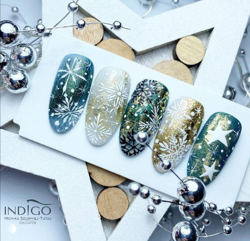 Сезонные типсы в зелёно-золотой гамме с новогодними снежинками и звёздами, сложный стемпинг и декоративные акценты для праздника.