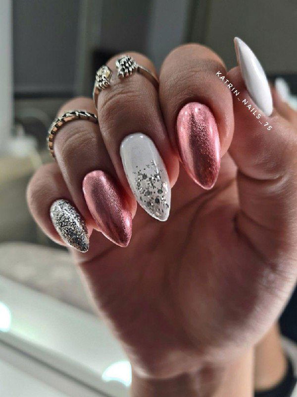 Рука с овальными ногтями: металлик розового тона, жемчужное покрытие и серебряный глиттер — сочетание втирки и блёсток для люксового эффекта.