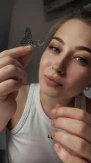 Крупный план Виктории Кораблевой у рабочего стола маникюра, она держит мелкий предмет и демонстрирует процесс теста вытяжки в рабочей среде