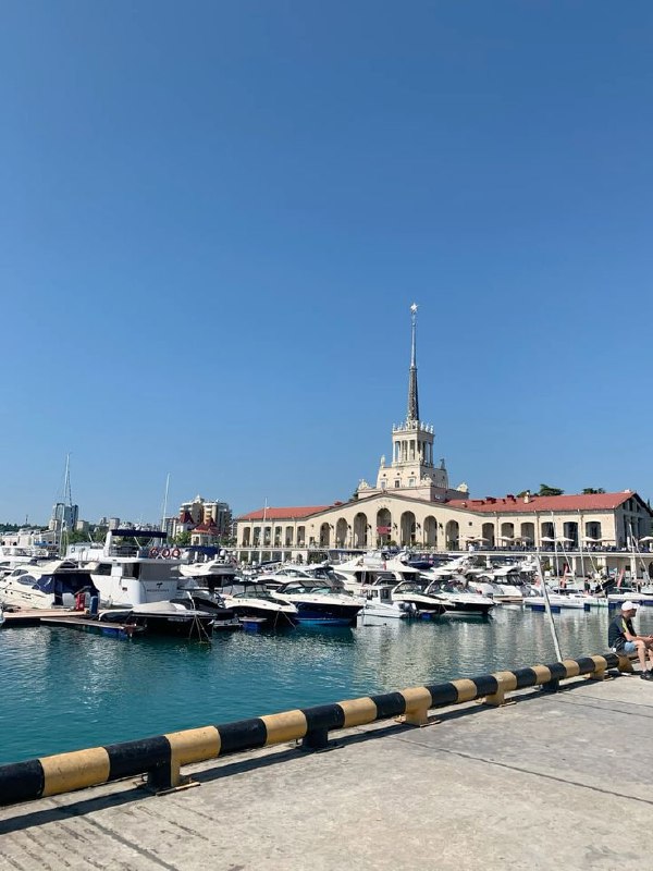 Яхтенная пристань и набережная в солнечный день, морская атмосфера курортного города Краснодарского края с прогулочными лодками