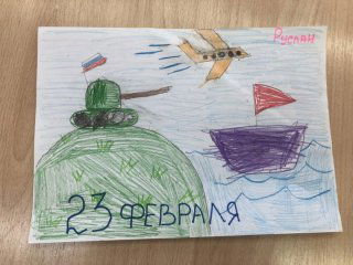 Детский рисунок: зелёный танк на холме, самолёт в небе, флаги и подпись «23 февраля», выполнен цветными карандашами на бумаге.