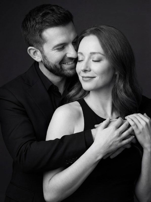 Фотореалистичный чёрно‑белый портрет пары: мужчина обнимает девушку, закрытые глаза у неё и лёгкая улыбка, высокая детализация кожи и ткани.