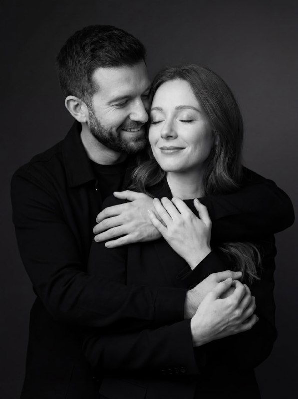 Студийный монохромный портрет пары в тёмной одежде, малая глубина резкости, аккуратные тени и ровная постановка тела по грудь.