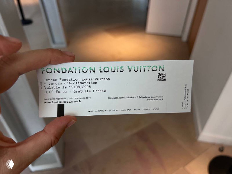 Билет Fondation Louis Vuitton в руке посетителя с видимым текстом и штрихкодом — доказательство посещения выставки и входной талон