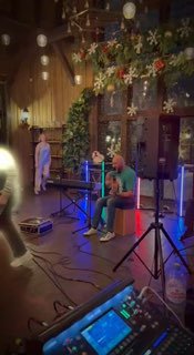 Музыкальное служение в церковном зале: музыкант у ударного и клавишного оборудования, фон — цветы и кресты, вечерняя подсветка.