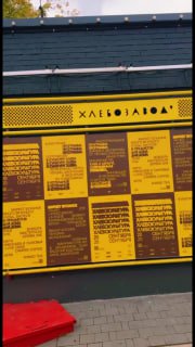 Вертикальная фотография уличного стенда с меню и надписью «Хлебозавод» — кадр из мобильного видео/Reels о местах, где купить хлеб.