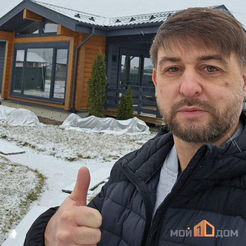 Портретный снимок Владимира, владельца компании «Мой1Дом», на фоне утеплённого дома — демонстрация автора и команды проекта.