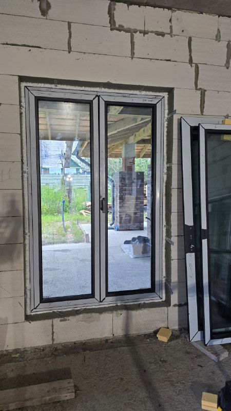 Трехстворчатое окно в проеме перед установкой: видны створки, импосты и подготовленные элементы для вклейки стеклопакета.