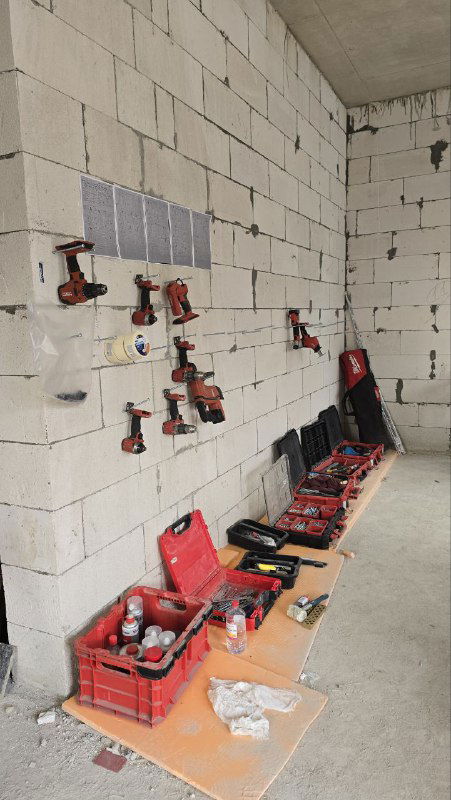 Инструменты и оборудование для установки окон: кейсы, уровни, дрели и расходные материалы аккуратно разложены на рабочем месте внутри объекта.