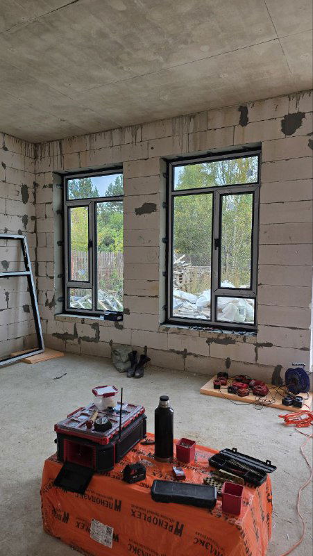 Внутренний вид установленных окон с инструментами на подоконнике; видна конструкция створок и пространство монтажной зоны внутри помещения.