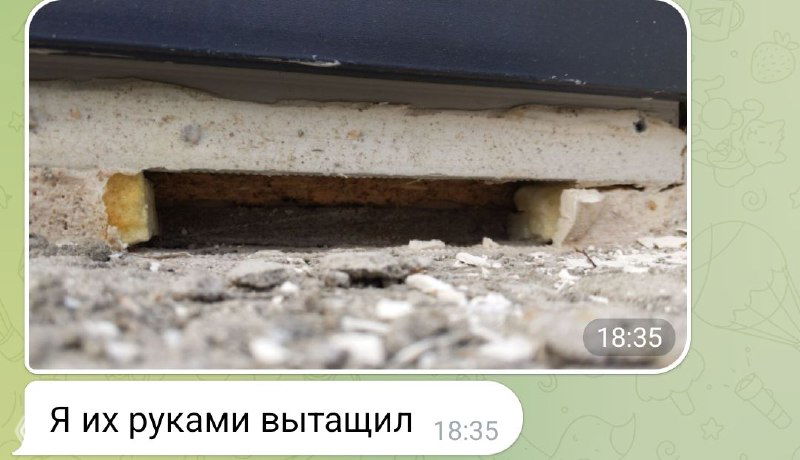 Крупный план щели под окном и торчащей монтажной пены, видна отделка откоса и следы плохого примыкания к стене из арболита.