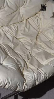 Крабик тёмно-коричневого оттенка на текстильном фоне кремового цвета, крупный план демонстрирует глянец и фактуру ацетата.