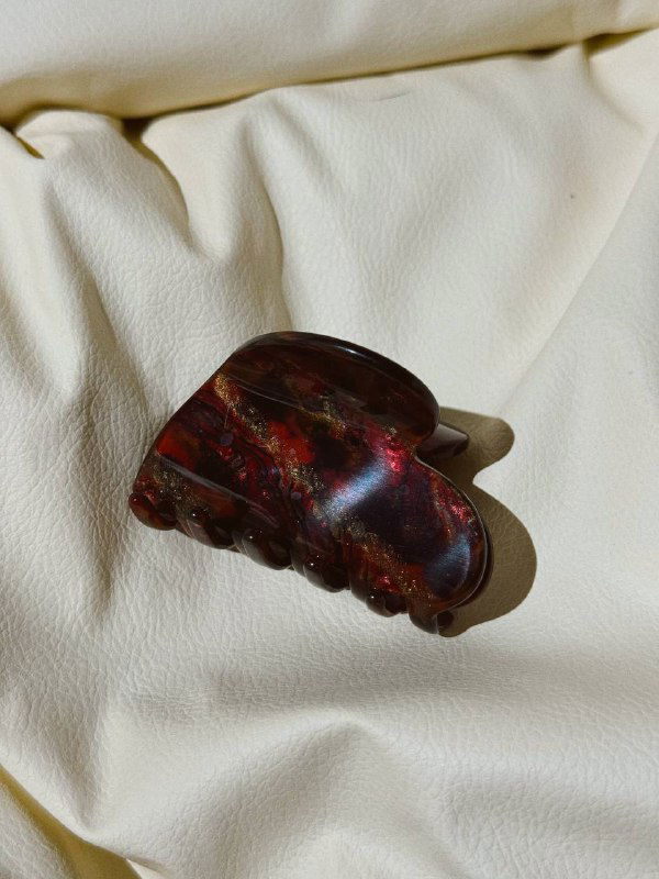 Крабик глубокого винного цвета с отражениями, размещён на складках кремовой ткани, видна текстура и форма аксессуара.