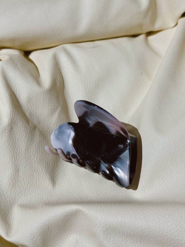 Классический черепаховый крабик из ацетата на светлом фоне, демонстрирующий характерные тёплые пятна и блеск материала.