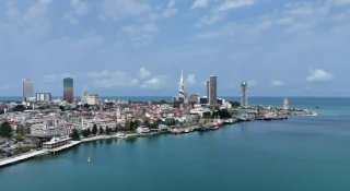 Панорамный вид побережья и центра Батуми с набережной, высотными домами и морем, иллюстрирующий район у въезда в город.