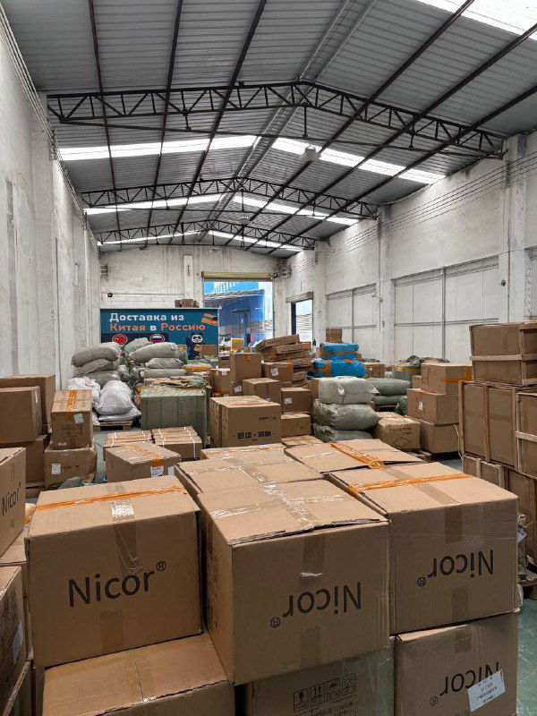 Крупный план стопки коробок на складе Panda28, на коробках видны ярлыки и упаковочная лента, готовые к инвентаризации и отправке.