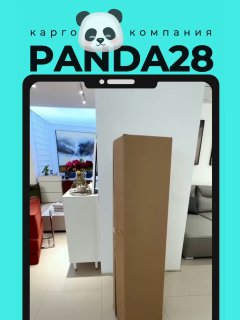 Вертикальная картонная коробка со спрессованной мебелью в упаковке на фоне салона: диван, витрина и интерьер магазина.