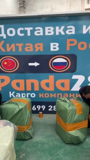 Несколько упакованных мешков и сотрудники на фоне стены с логотипом Panda28 — этап подготовки посылок к отправке.