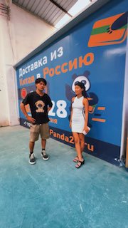 Кадр из видео: интервью на складе Panda28 во Фошане — интервьюер и сотрудник на фоне баннера «Доставка из Китая в Россию», видна складская зона.