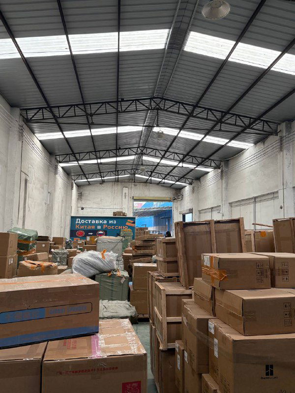 Внутреннее пространство склада Panda28 с рядами коробок, паллет и знаками безопасности; видны упаковки и проходы между стеллажами.