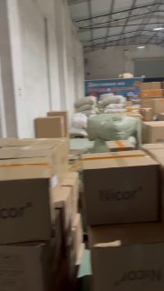 Внутренний вид склада с коробками и мешками, стопки упакованных товаров на полу в процессе консолидации и сортировки отправлений