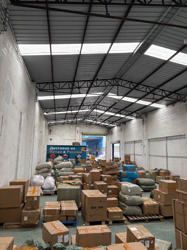 Широкий вид ангара Panda28: высокий потолок, множество коробок и мешков, подготовленных к отправке, организация складского пространства