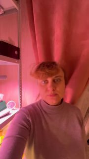 Автор у полки с рассадой под розово-фиолетовой фитоподсветкой; селфи в комнате, иллюстрация использования маломощных ламп.