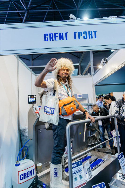 Необычный стенд с промоутером в образе и чувственным реквизитом; посетители останавливаются посмотреть экспозицию и сфотографироваться.