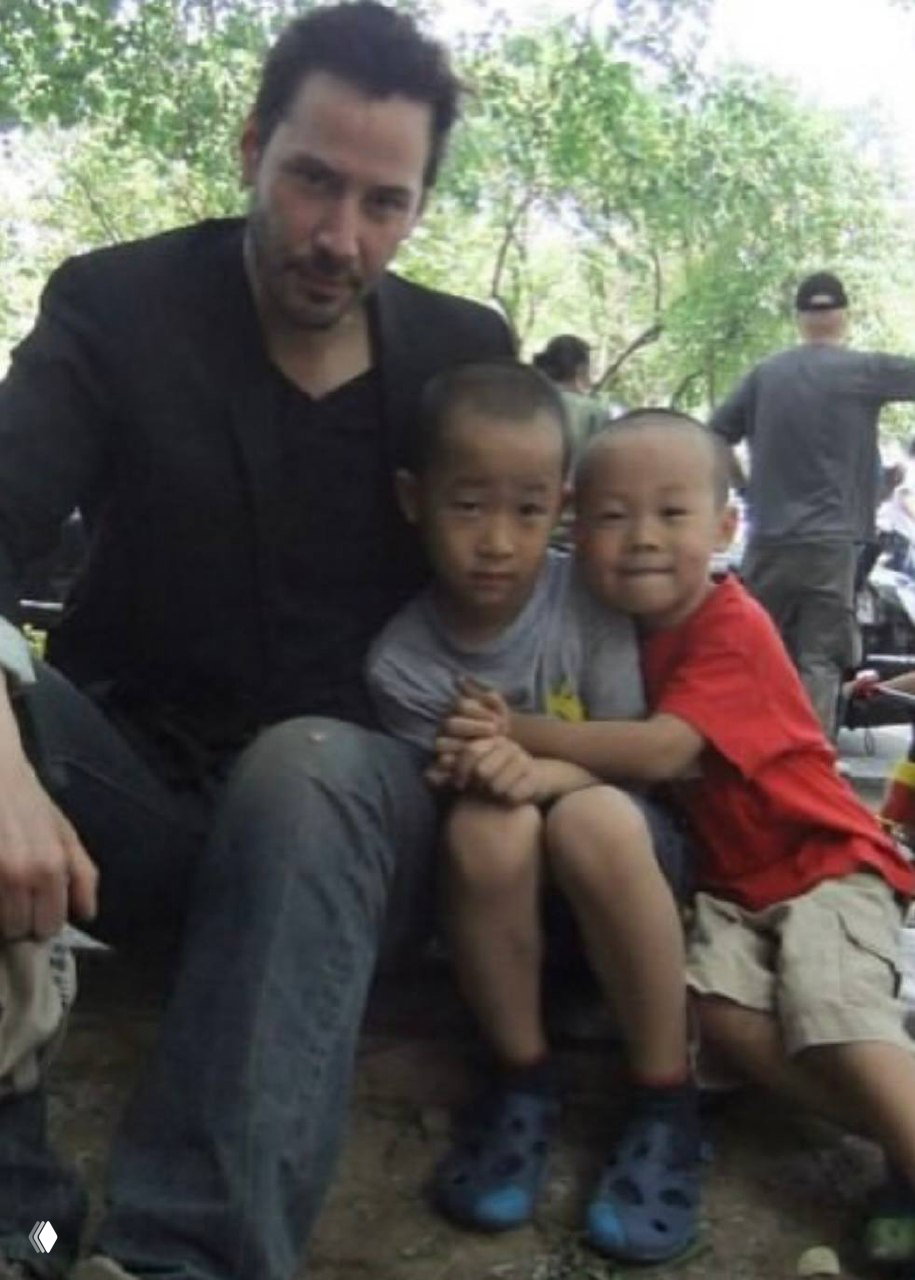 Мужчина фотографируется в парке с двумя детьми, тёплая сцена общения и доброжелательности на открытом воздухе, семейная атмосфера.