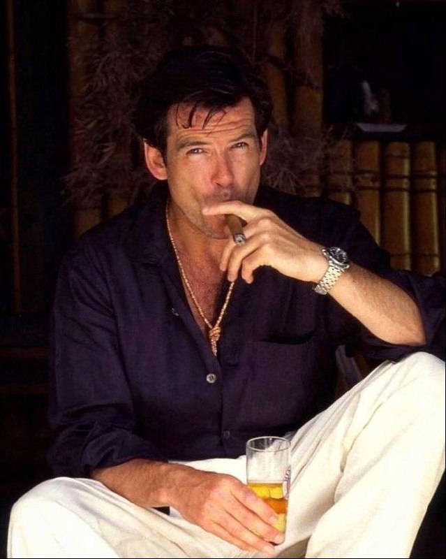 Мужчина в расслабленной позе с сигарой и бокалом напитка, кадр передаёт эстетическую сторону ритуала и вечернюю атмосферу.