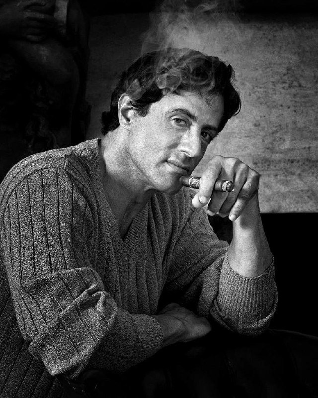 Черно-белый портрет мужчины с сигарой, стильный кадр в классической эстетике, дым подчёркивает черты лица и настроение.