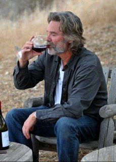 Мужчина в непринуждённой рубашке сидит на скамейке и пьёт вино; спокойная сцена про наслаждение взрослением и медленную роскошь повседневности.