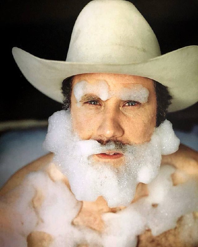 Портрет человека в ковбойской шляпе с пеной на лице; стилизованный рекламный или редакционный снимок с редакционной эстетикой.