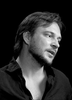 Профильный черно‑белый портрет спикера, задумчивый взгляд, студийный фон, кадр из выпуска «Голая правда» о внутренней уверенности.