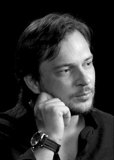 Крупный черно‑белый портрет спикера, рука у подбородка, задумчивый взгляд в кадре — визуальный материал к выпуску о смелости и спокойствии.