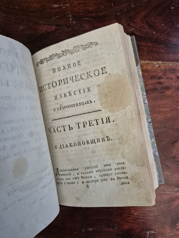 Открытая книга: титульный лист с надписью «Полное историческое известiе» и следами старения бумаги и пятном на странице.