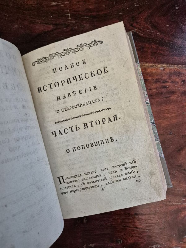 Ещё один разворот издания: вид страницы с заголовком части и фрагментом текста о старообрядцах, заметны старинная типографика и пожелтевшая бумага.