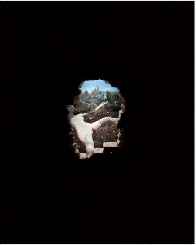 Тёмный кадр с отверстием/ключом, через которое видна миниатюрная сцена — сюрреалистическая перспектива и игра с масштабом.