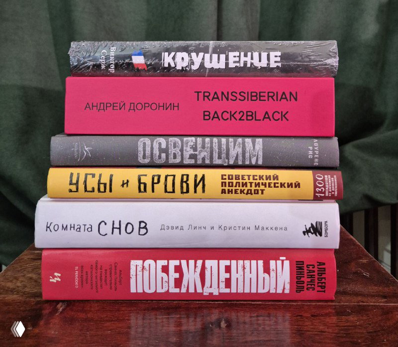 Стопка книг в упаковке и без на зелёном фоне: видны корешки с названиями «Побежденный», «Transsiberian Black2Black» и др.