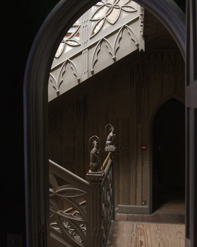 Вид через арку на лестницу и верхнюю галерею библиотеки Strawberry Hill House: скульптурные столбики, резьба и полутени интерьера.