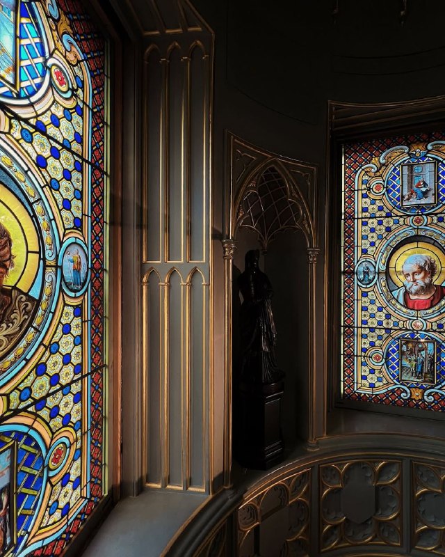 Детали витража и окантовки окна в библиотеке Strawberry Hill House: медальонные изображения на цветном стекле и изящная деревянная отделка.