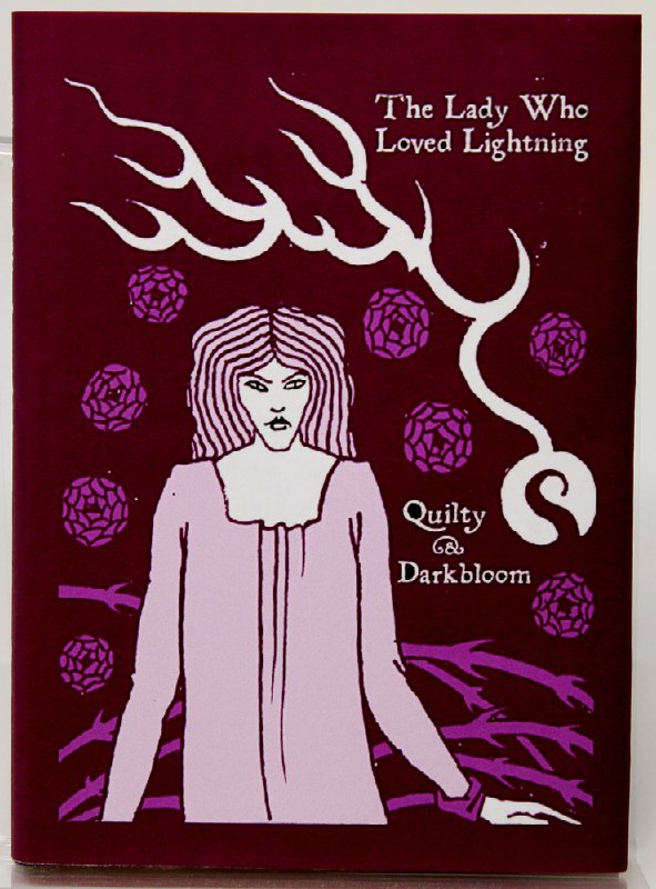 Фиолетовая обложка с иллюстрацией женщины и надписью «The Lady Who Loved Lightning», стилизация драматической пьесы, представленной на выставке.