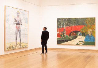 Интерьер музея с посетителем перед крупными полотнами на стенах; подчёркнуты масштаб работ и музейная перспектива экспозиции.