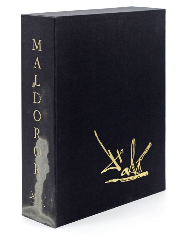 Корешок и обложка альбома с вертикальным тиснением слова MALDOROR и золотым рисунком на темном фоне — вид со стороны переплёта лимитированного издания.