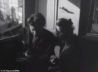 Интимный кадр внутри вагона или трамвая: двое пассажиров вполоборота, они держат небольшой предмет, кадр подчёркивает близость и взаимодействие с устройством в руках.