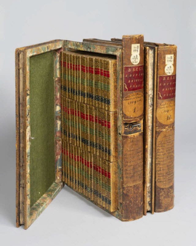 Открытый футляр-библиотека в виде книги с набором тонких карманных томов внутри — вид на срез корешков и плотный ряд миниатюрных блоков с красными плашками.