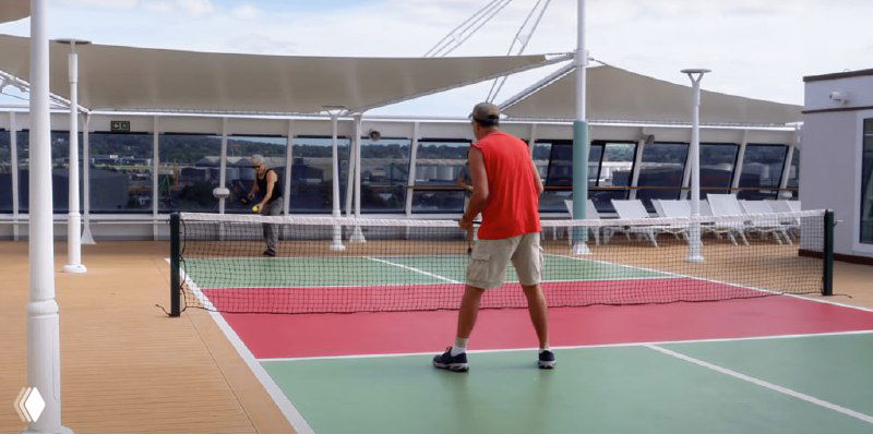 Спортивная площадка на открытой палубе — игрок в рубашке красного цвета и линия для активного отдыха пассажиров на свежем воздухе.