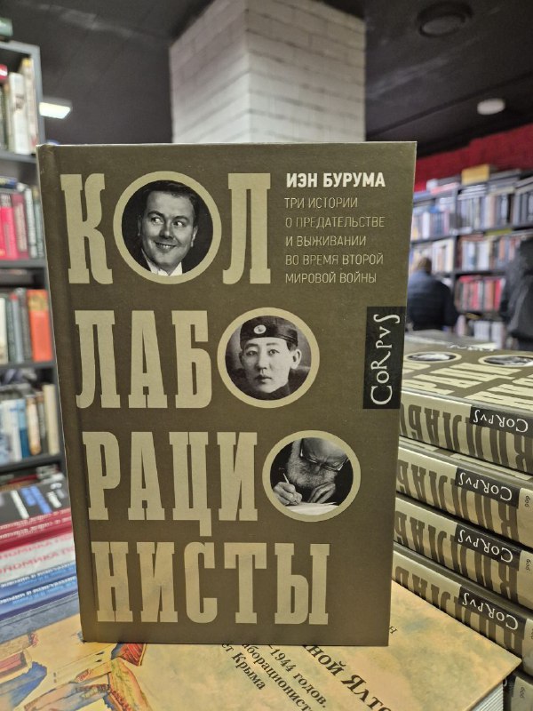 Фотография издания Иэна Бурумы «Коллаборационисты» в мягкой обложке на прилавке — крупный план обложки и окружение книжного магазина.